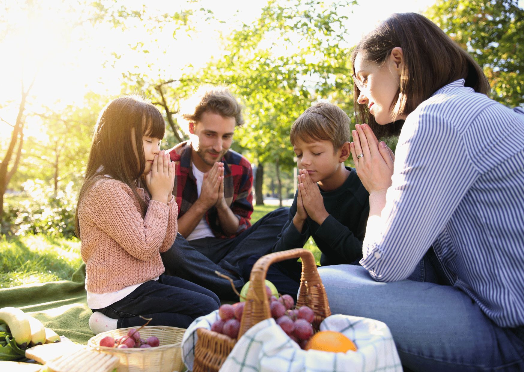 family praying before sharing a meal 