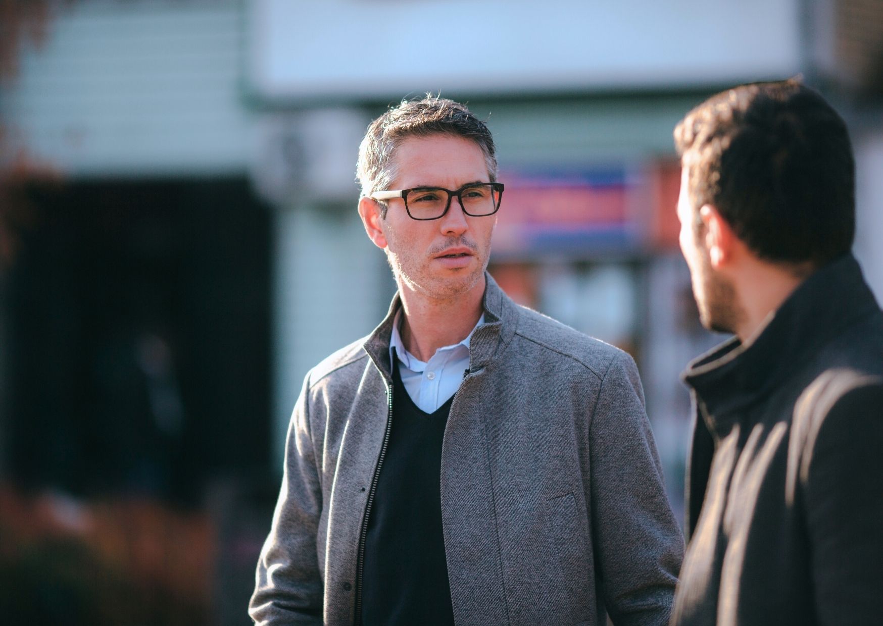Two people walking together on a neighborhood street, mid-conversation — life-on-life discipleship in everyday rhythms