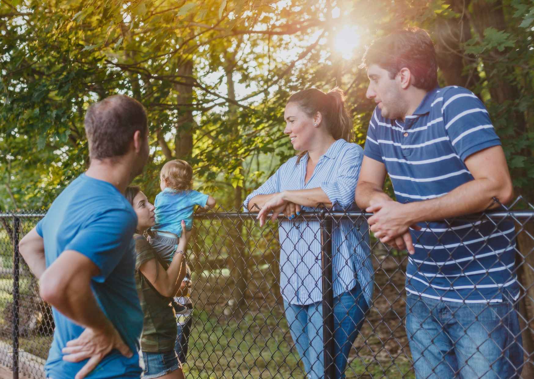 A candid neighborhood conversation scene with neighbors and friends, real conversation, natural outdoor light