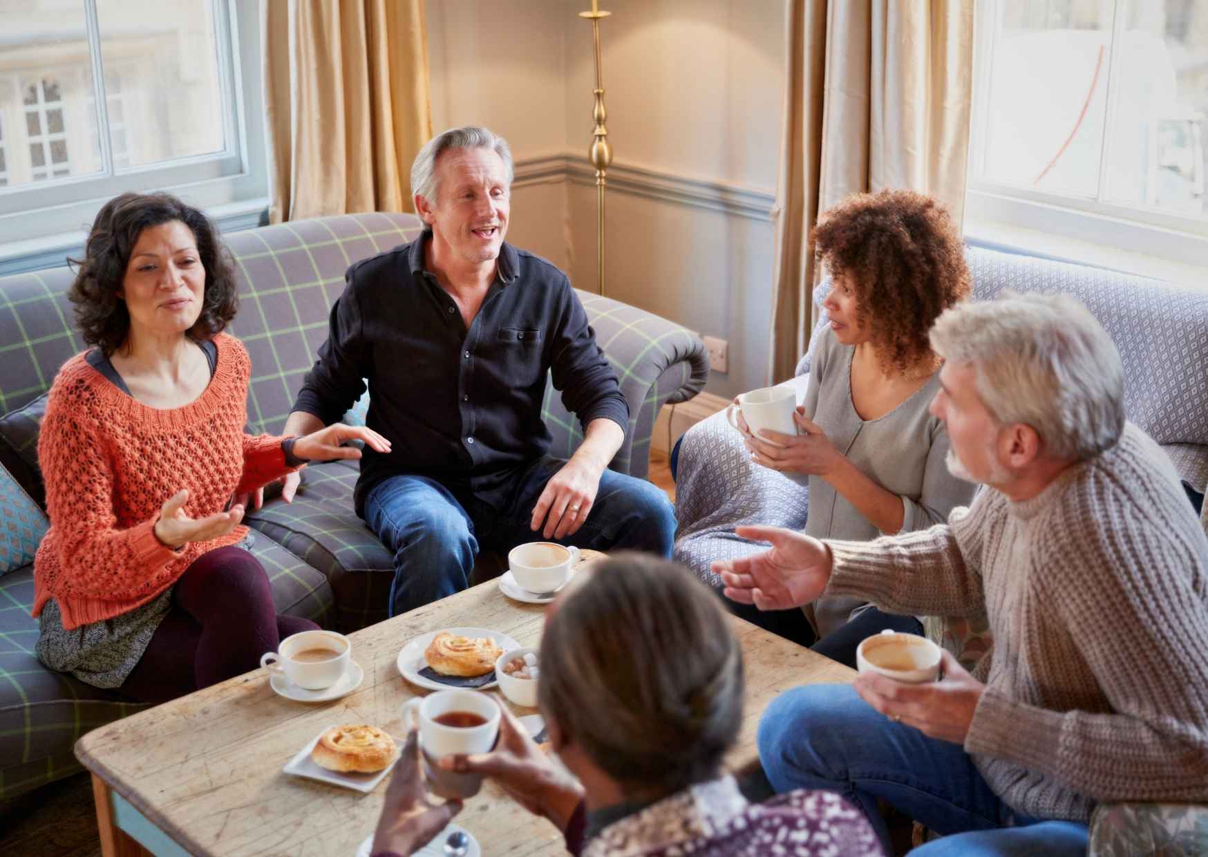 Adults in casual kitchen conversation, genuine and unposed