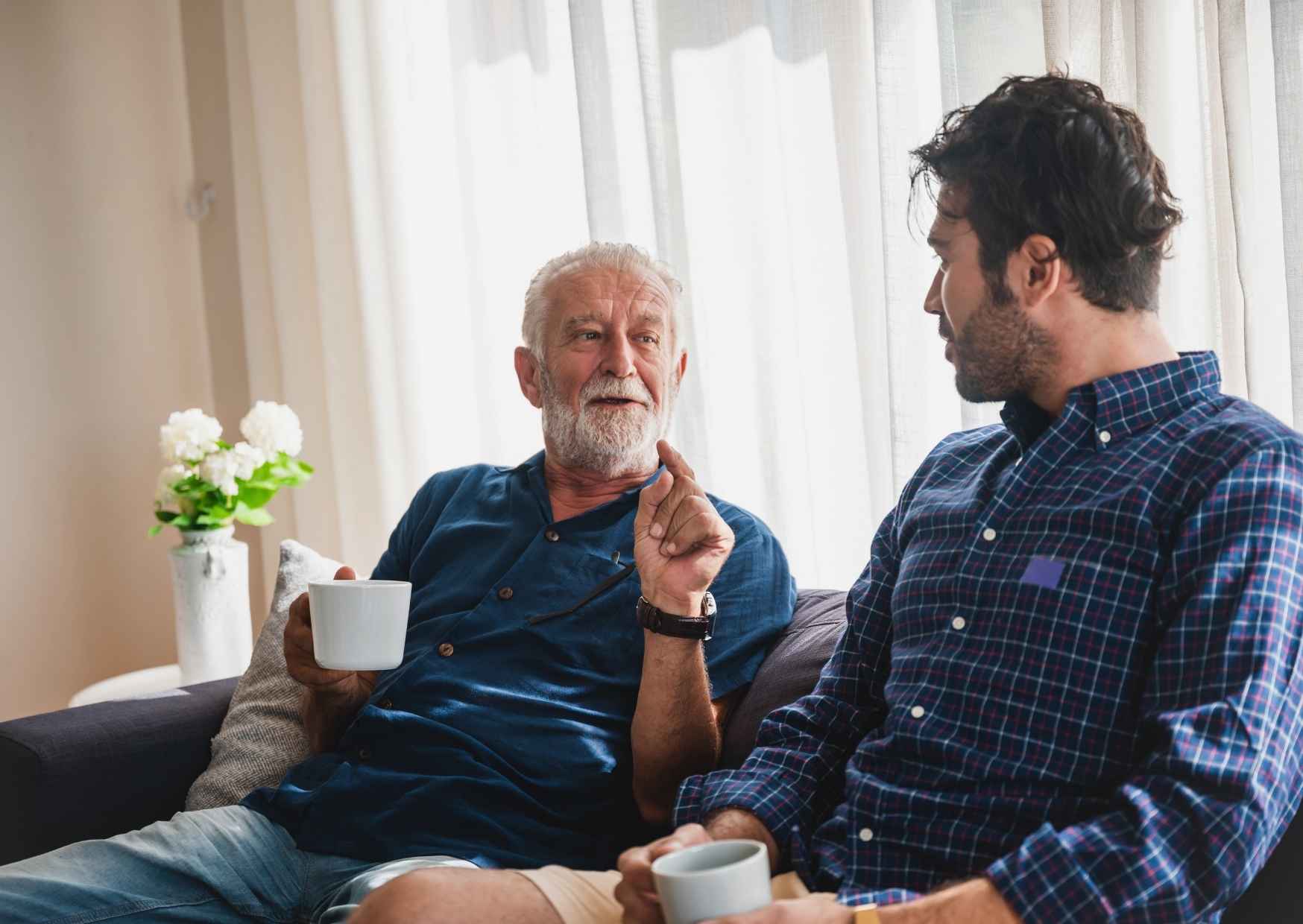 Parent in casual conversation with a teenager in a living room, genuine connection not performance