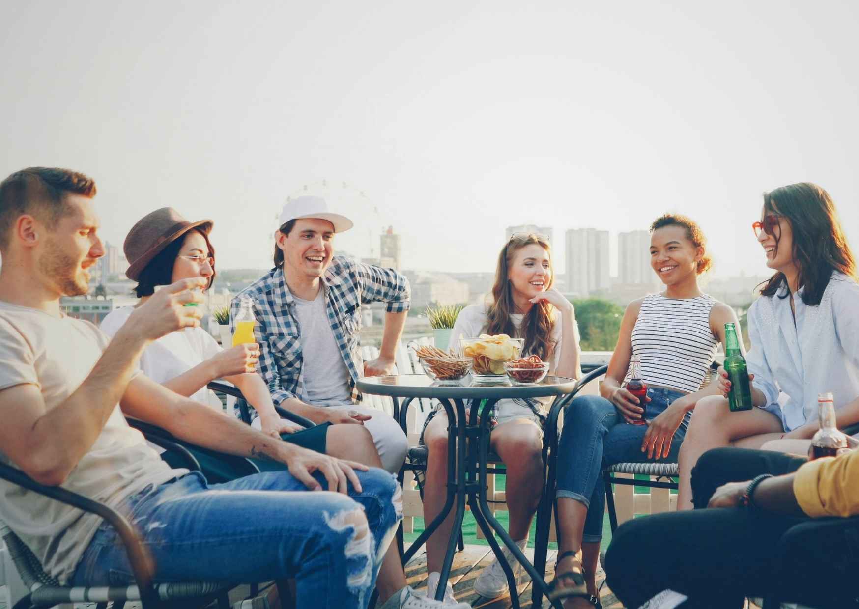 Small group of two or three adults laughing and talking casually, relaxed and at ease with each other